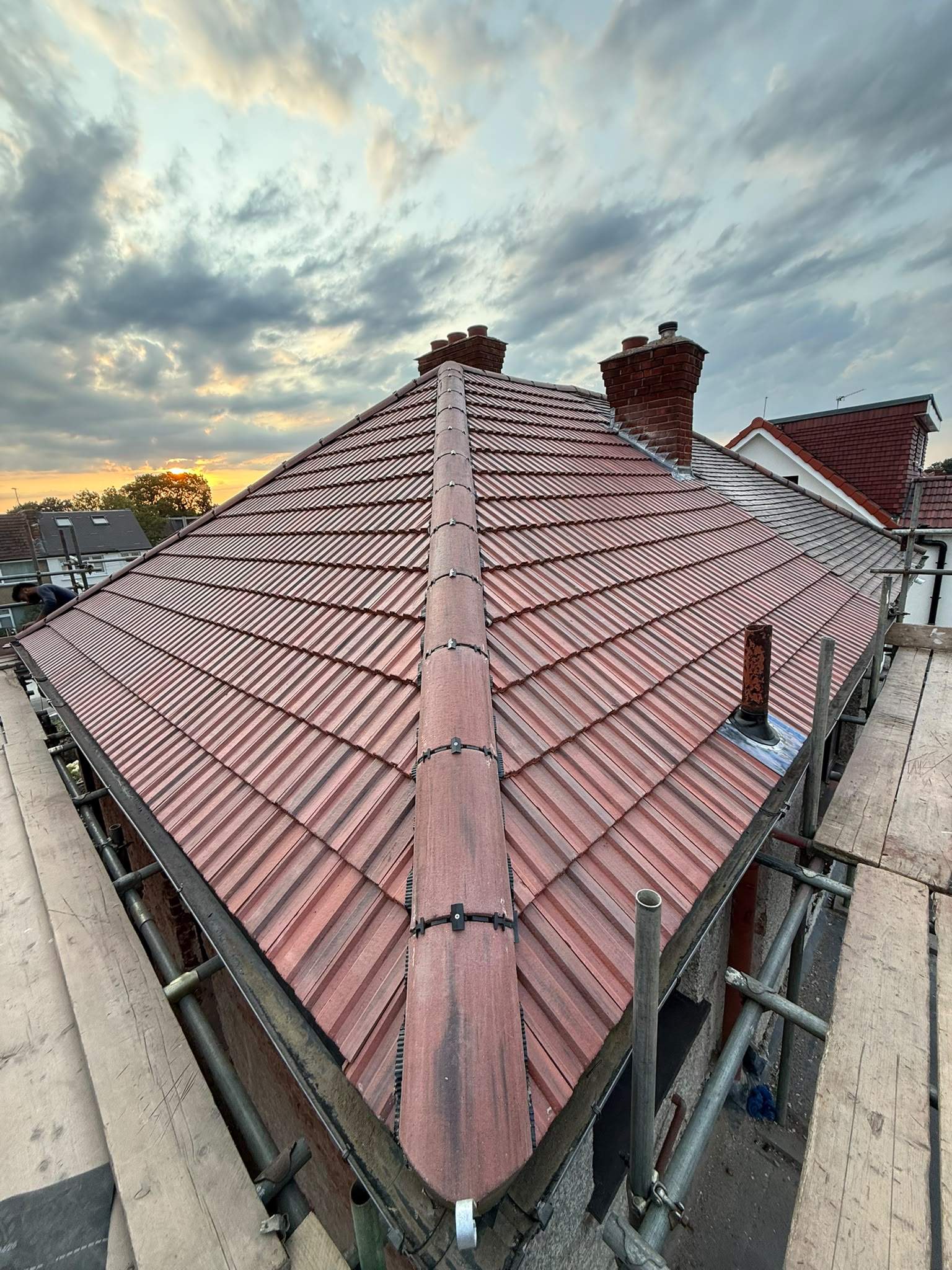 Red roof tiles, hip ridges and chimney