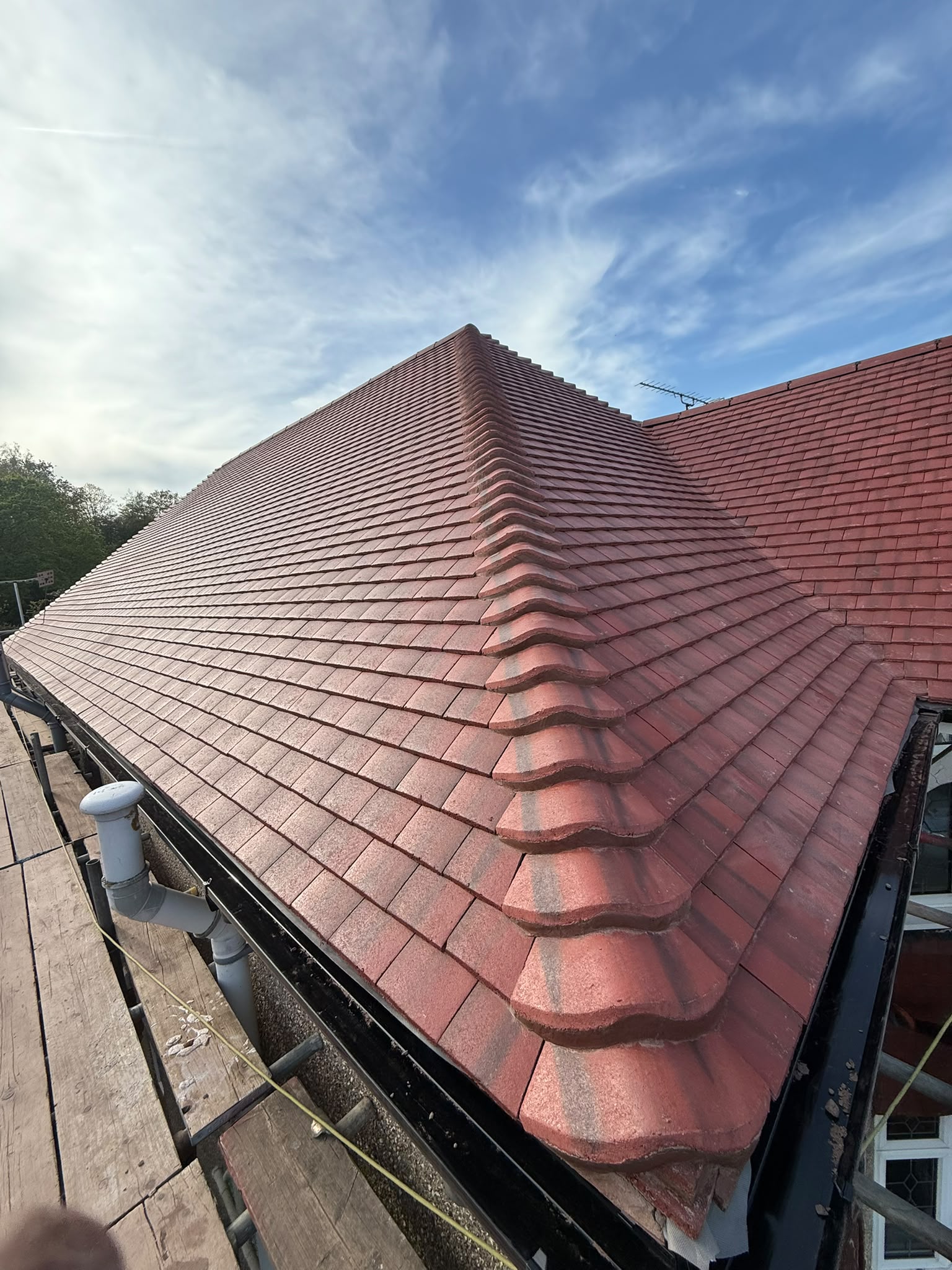 Red tiled hip roof viewed from scaffolding