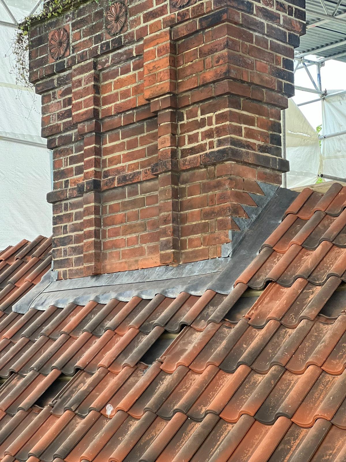 Lead flashing around the base of a brick chimney