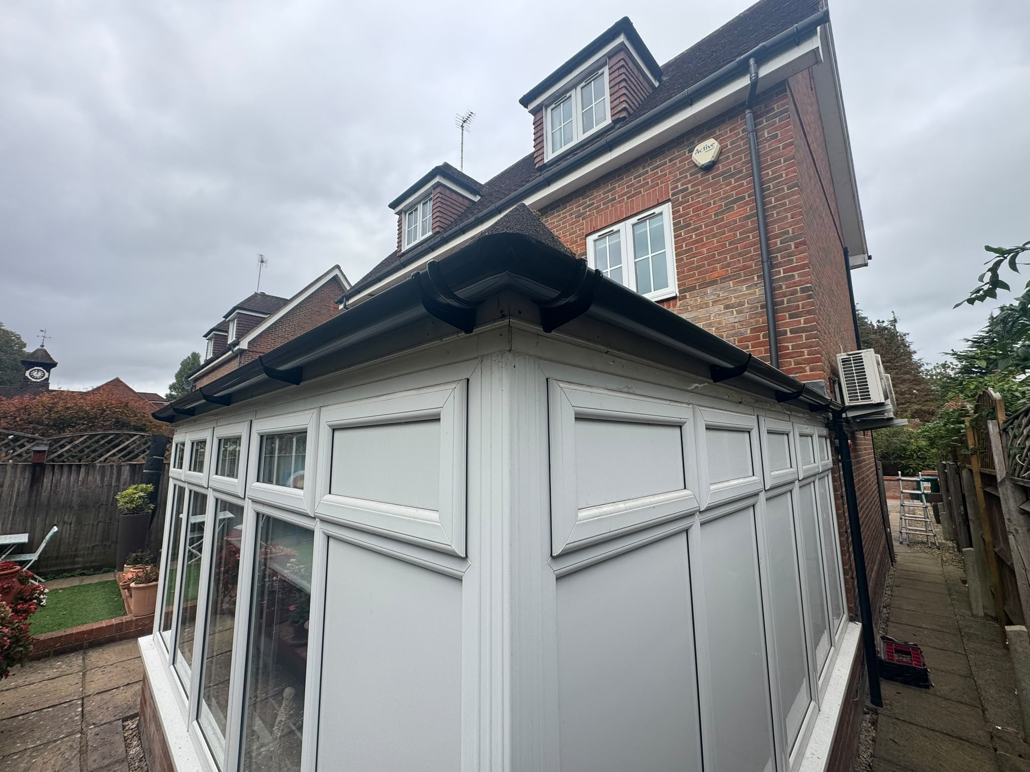Roofline and gutters above a white conservatory